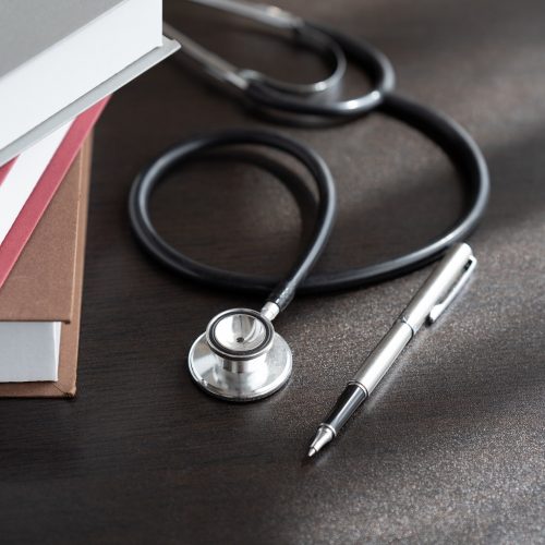 Medical student textbooks with pen and stethoscope on table. medical education medicine books and notes on the table.